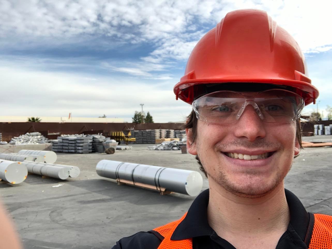 Worker standing in front of large aluminum cylinders